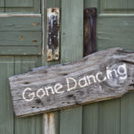 Old gone dancing sign on green doors.